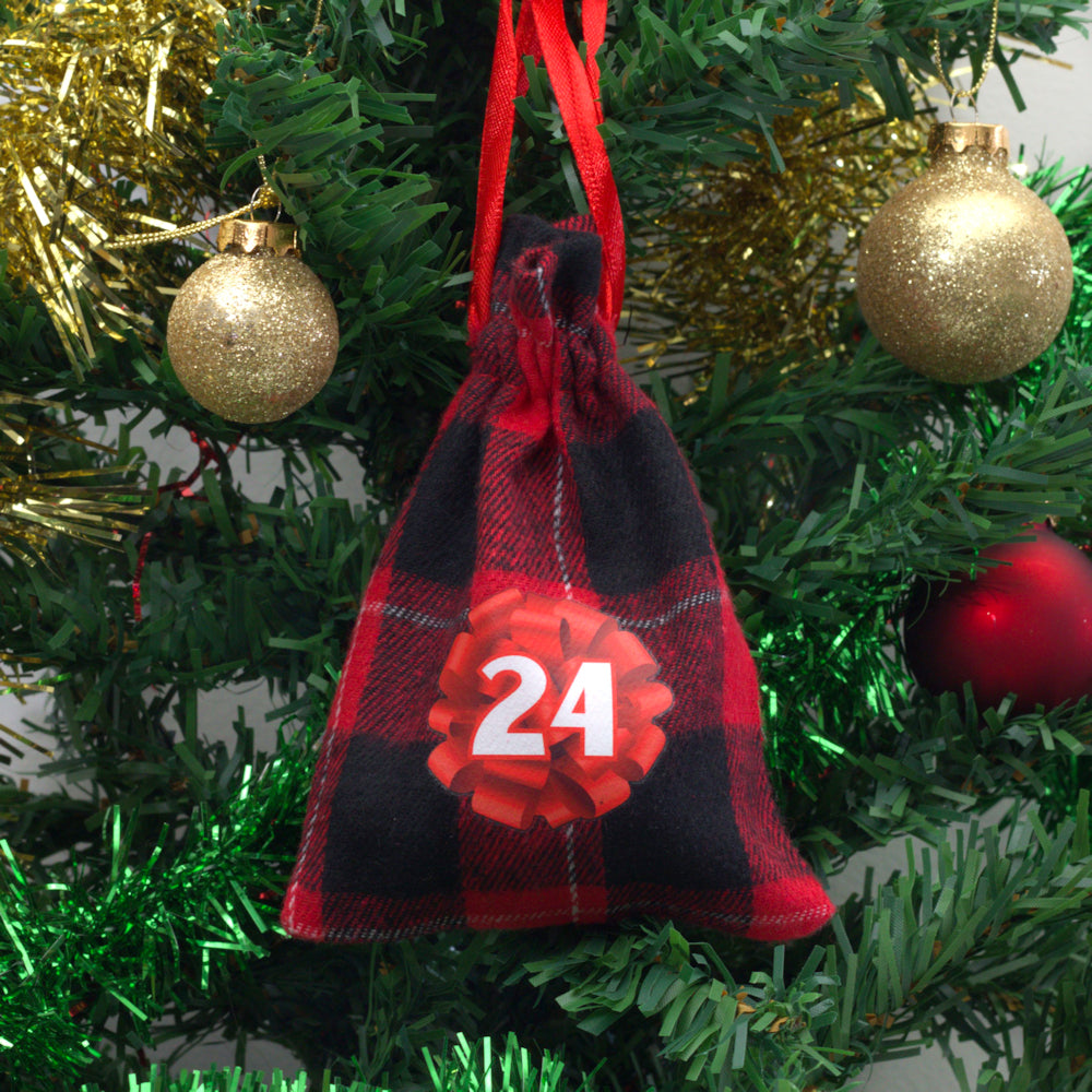 A kiwiana inspired cotton bag filled with a child toy hanging from a Christmas tree