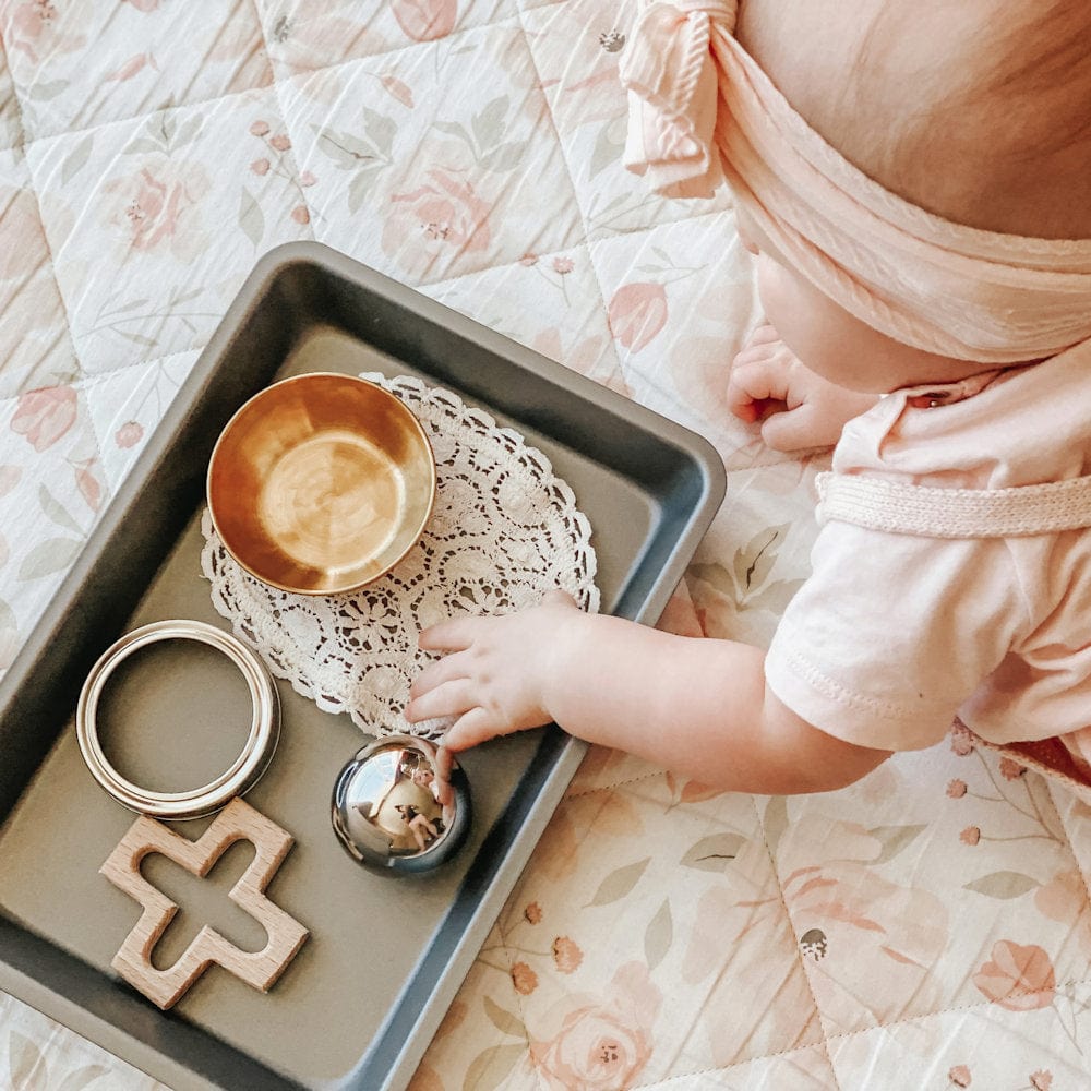 Close-up of child’s hands grasping natural play materials. Sensory exploration through open-ended, Montessori-inspired play.